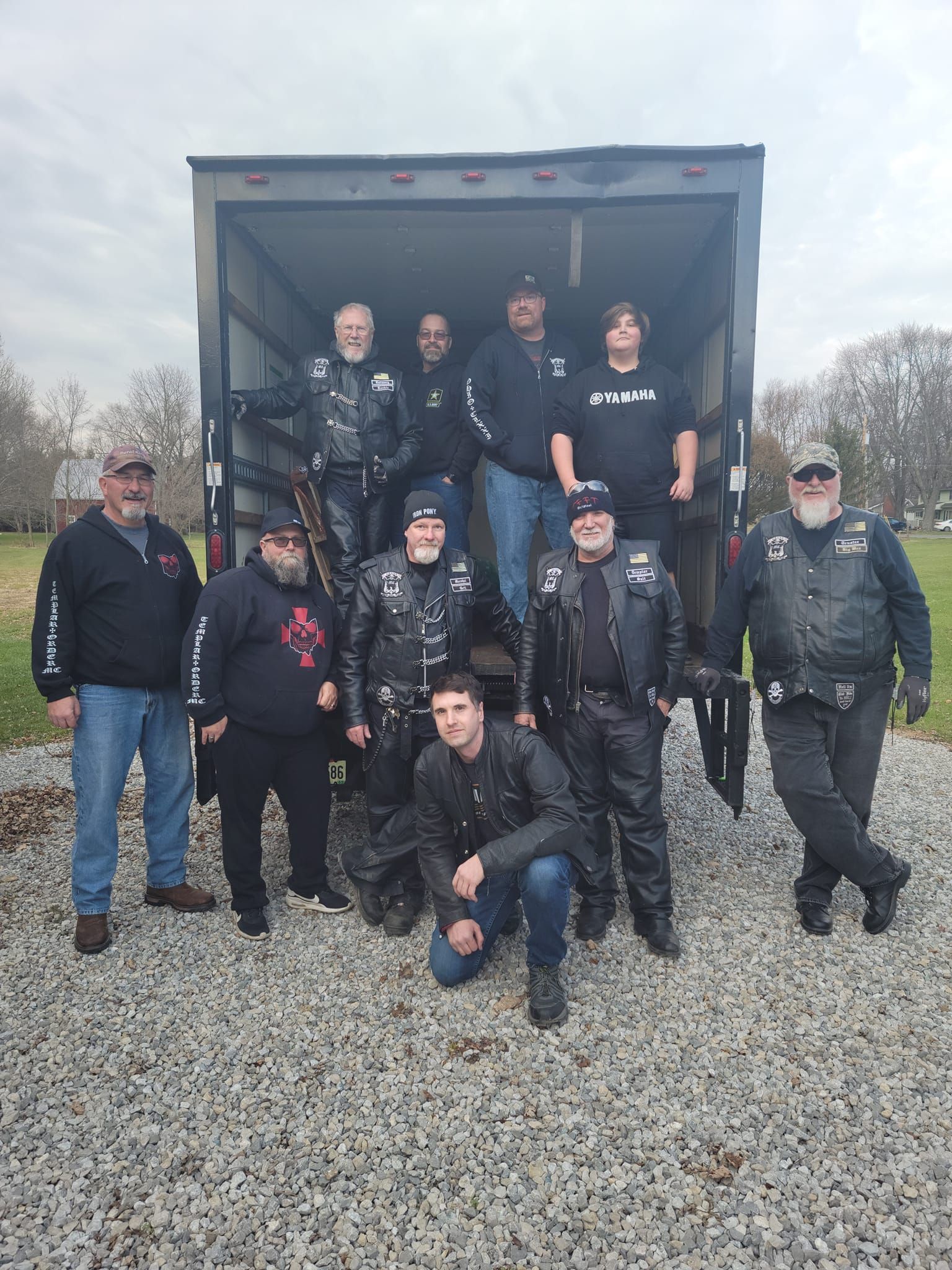 A group of men are posing for a picture in front of a truck.