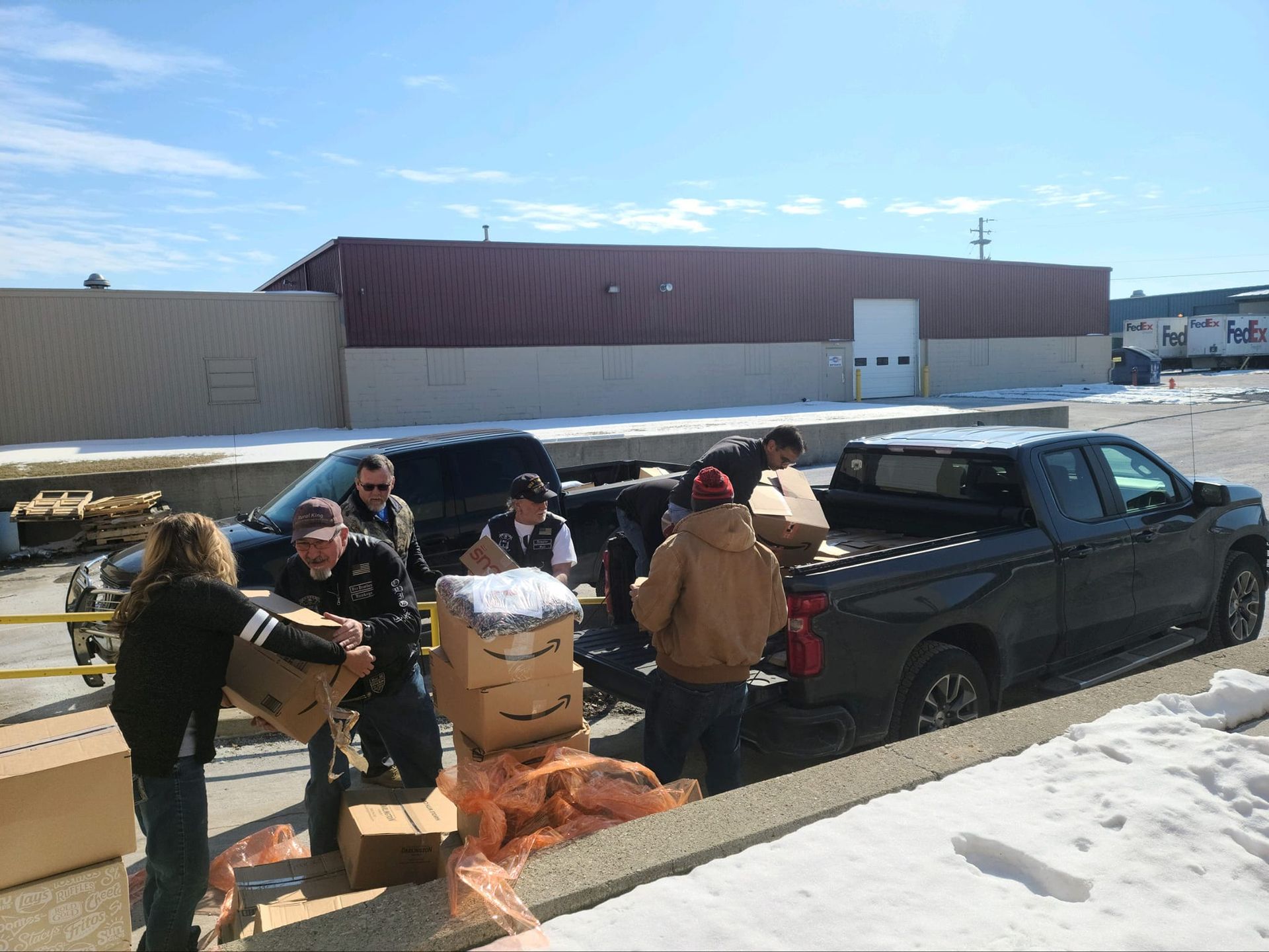 A group of people are loading boxes into the back of a truck
