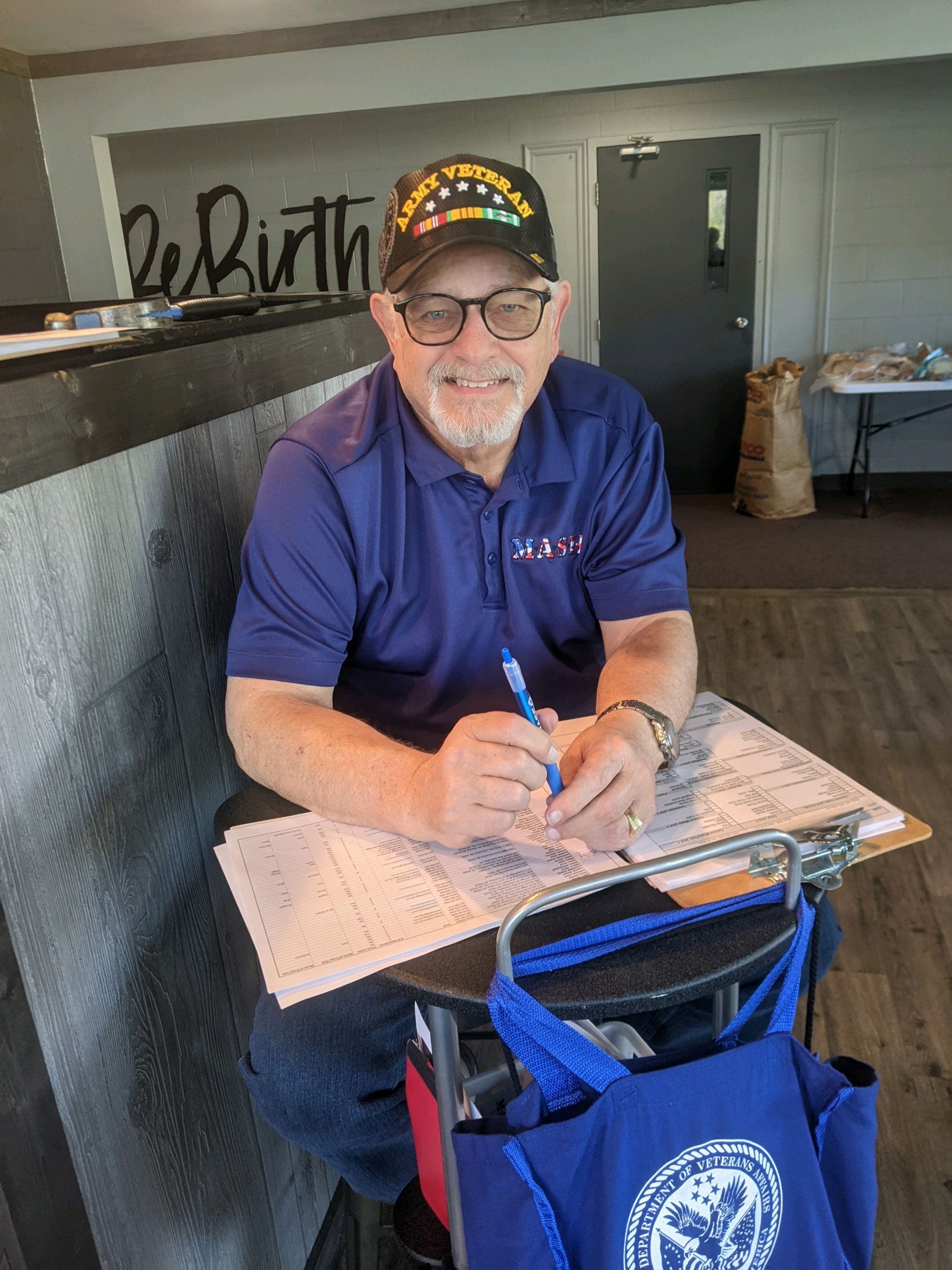 A man is sitting at a desk writing on a piece of paper.