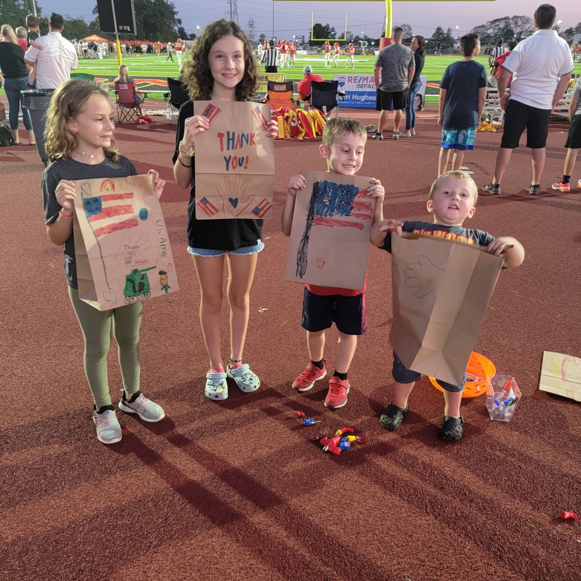 A group of children are holding bags that say thank you