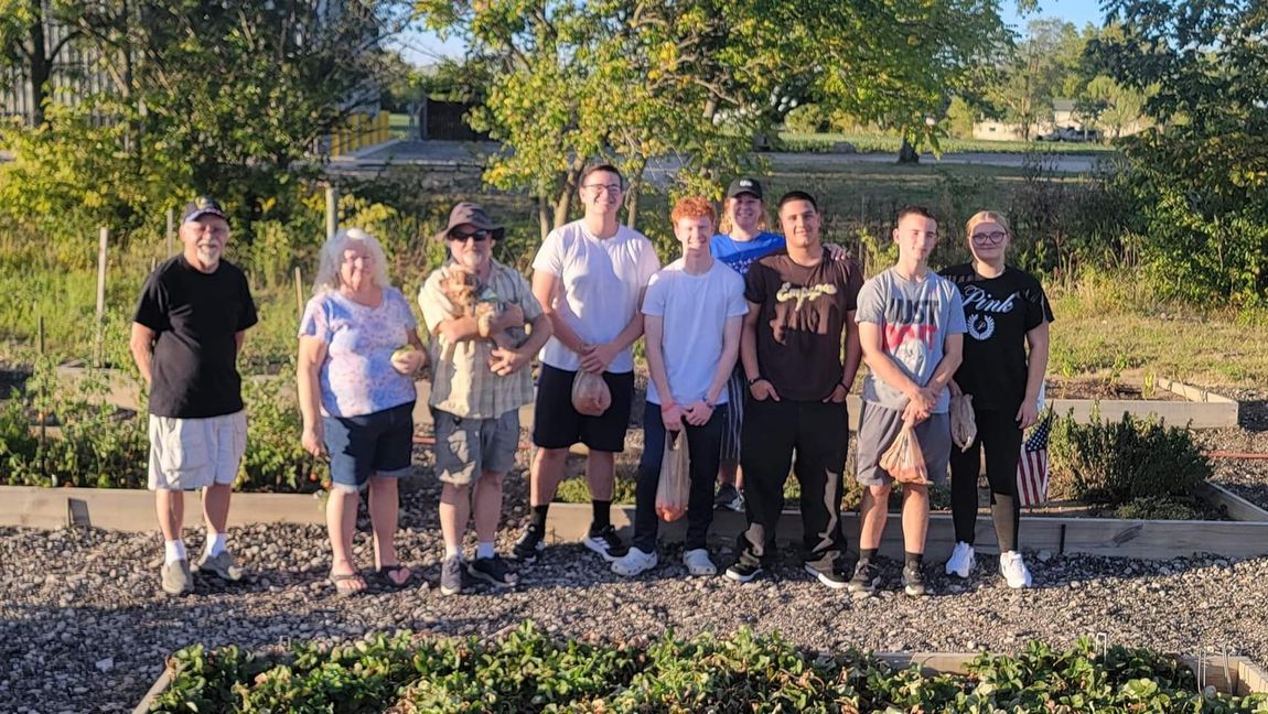 A group of people are posing for a picture in a garden.