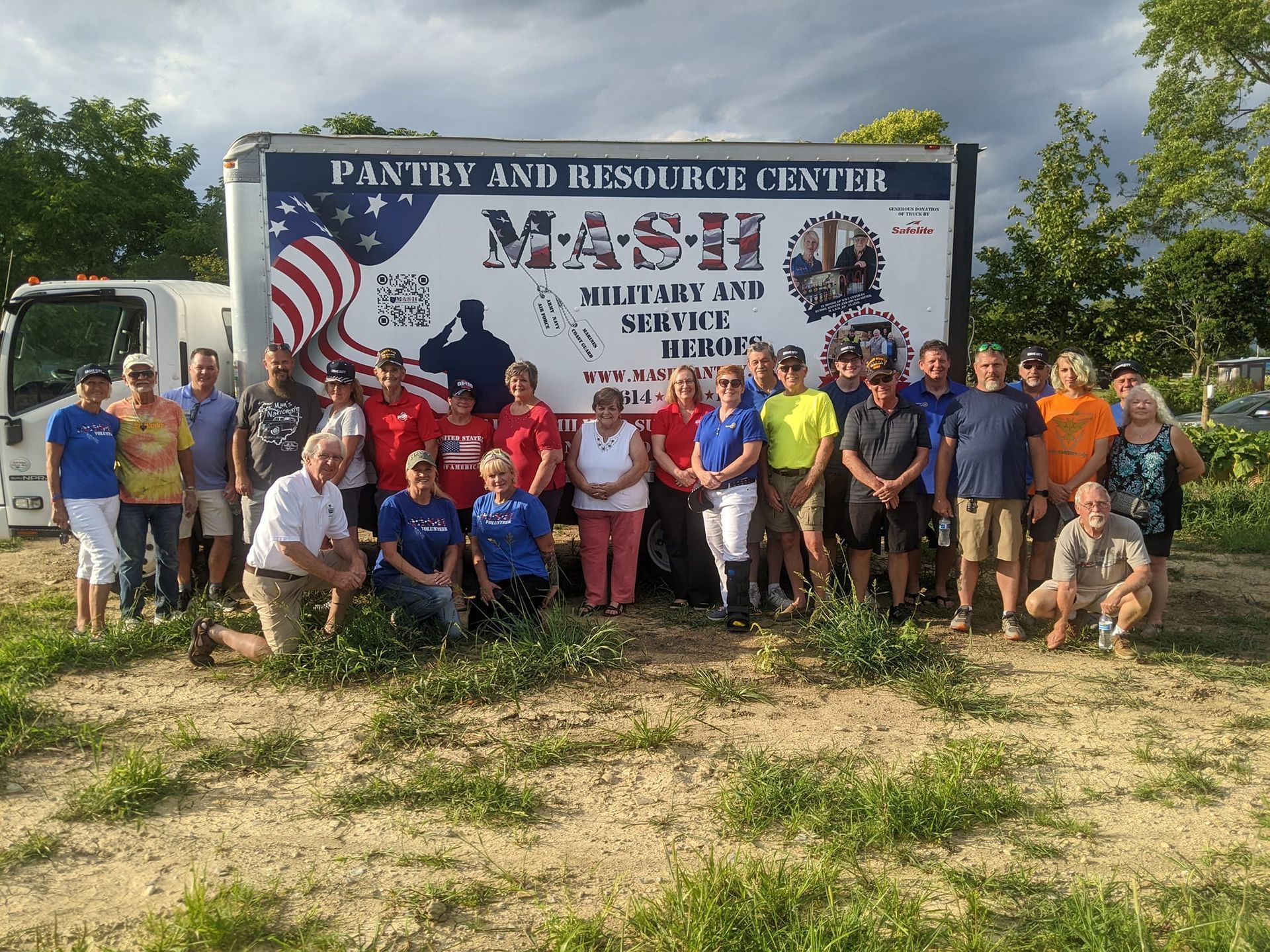 A group of people standing in front of a sign that says mash pantry and resource center