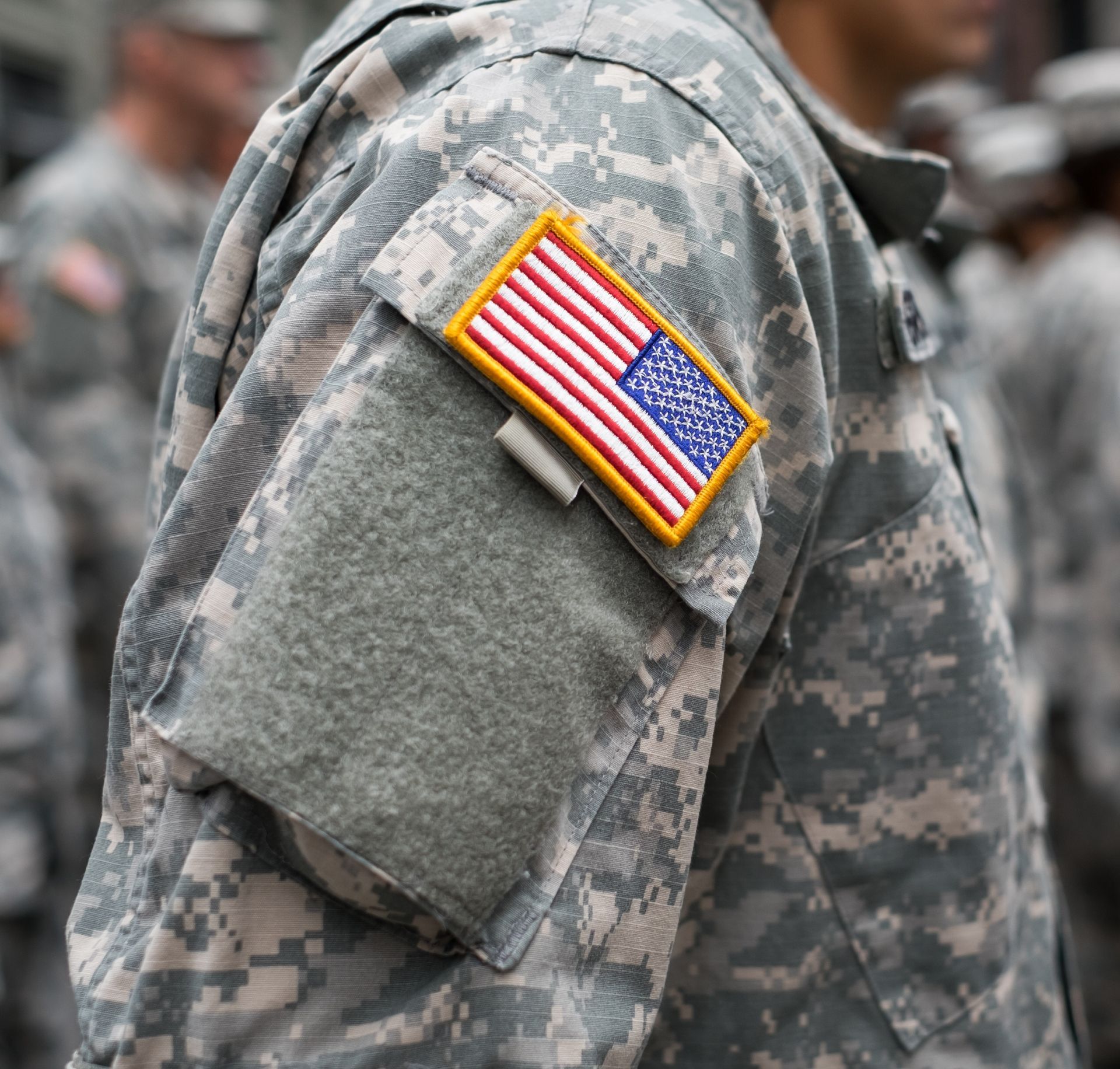 A soldier has an american flag patch on his sleeve