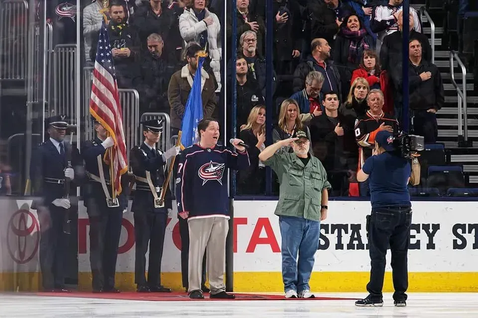 A group of people standing on top of a hockey rink.