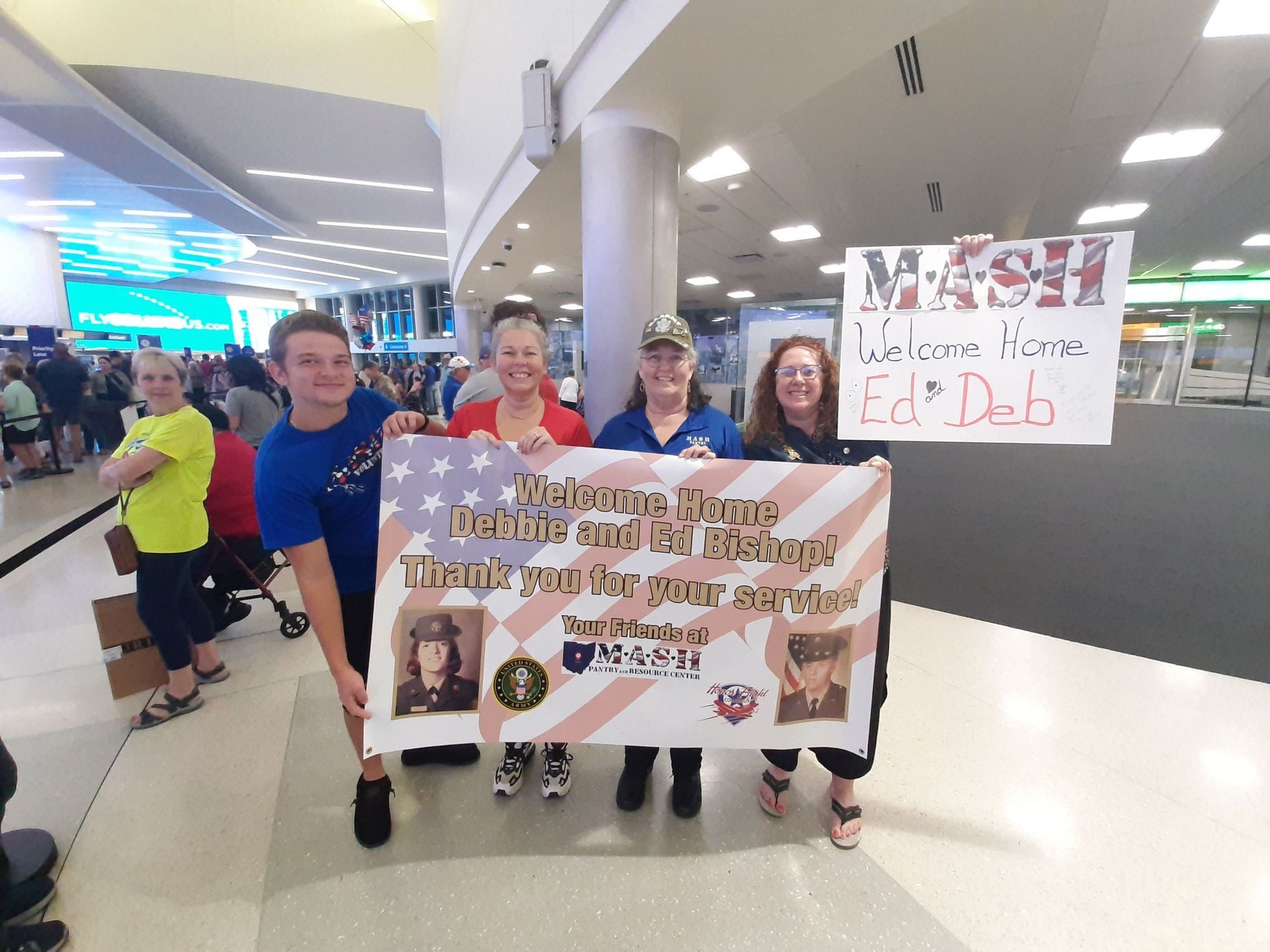 A group of people holding a sign that says marsh