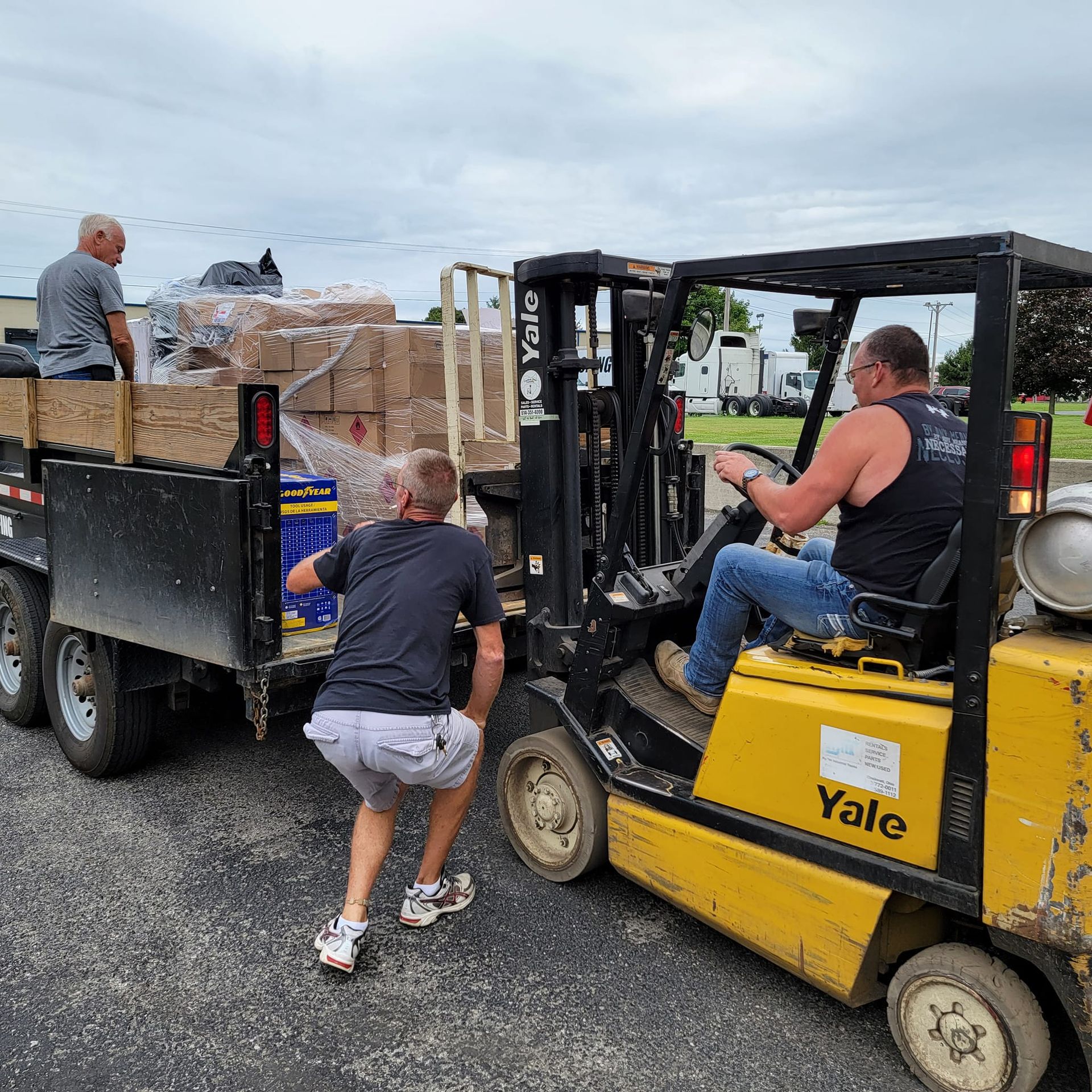 A man is pushing a yellow yale forklift