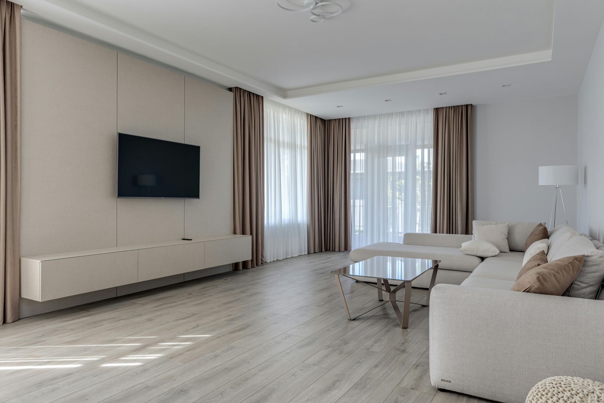 A living room with a couch , table , television and curtains.