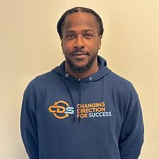 A Black man with braided hair wearing a blue hoodie with 