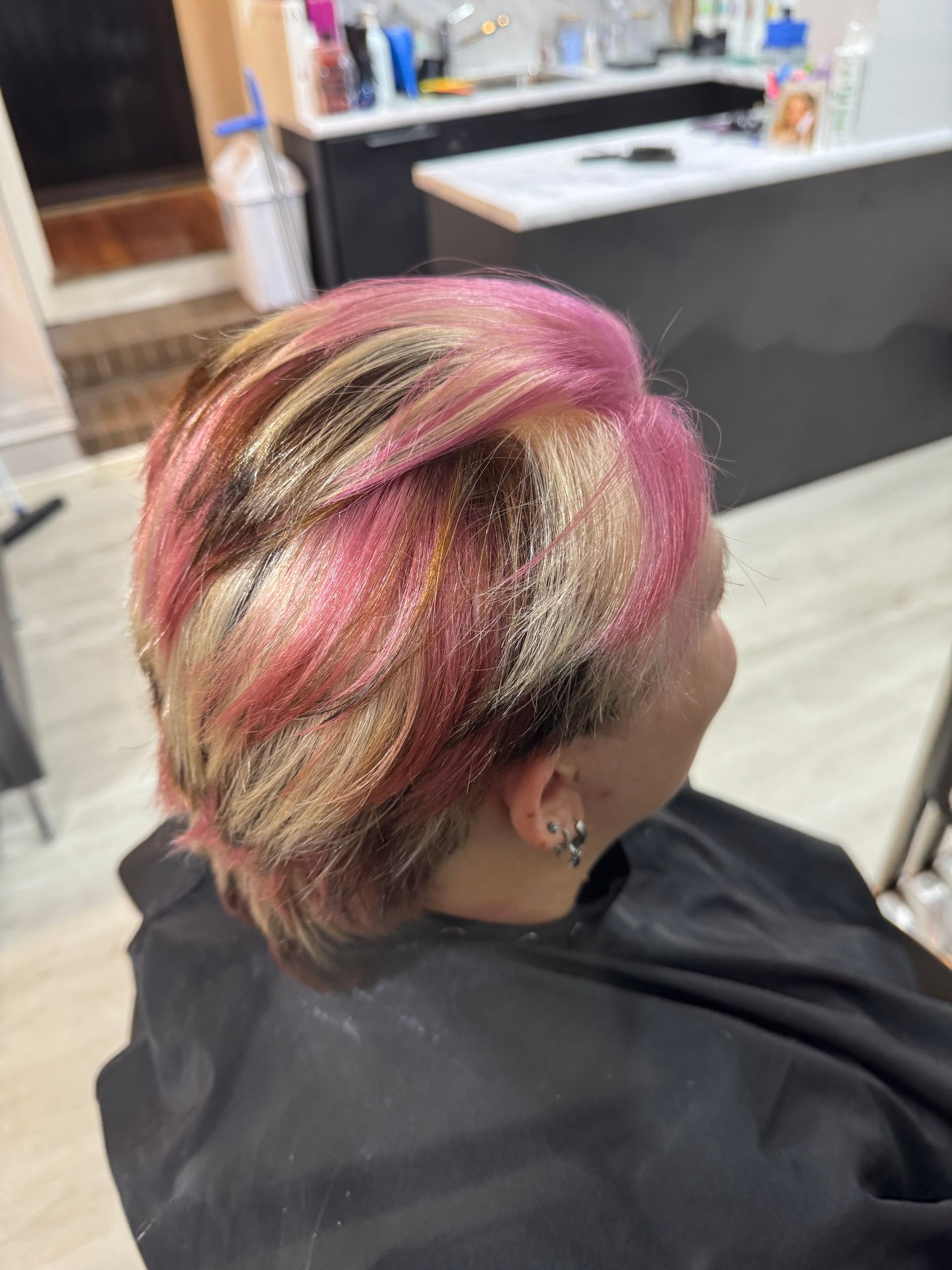 Pink, blonde, and black hair styled in salon, viewed from the back.