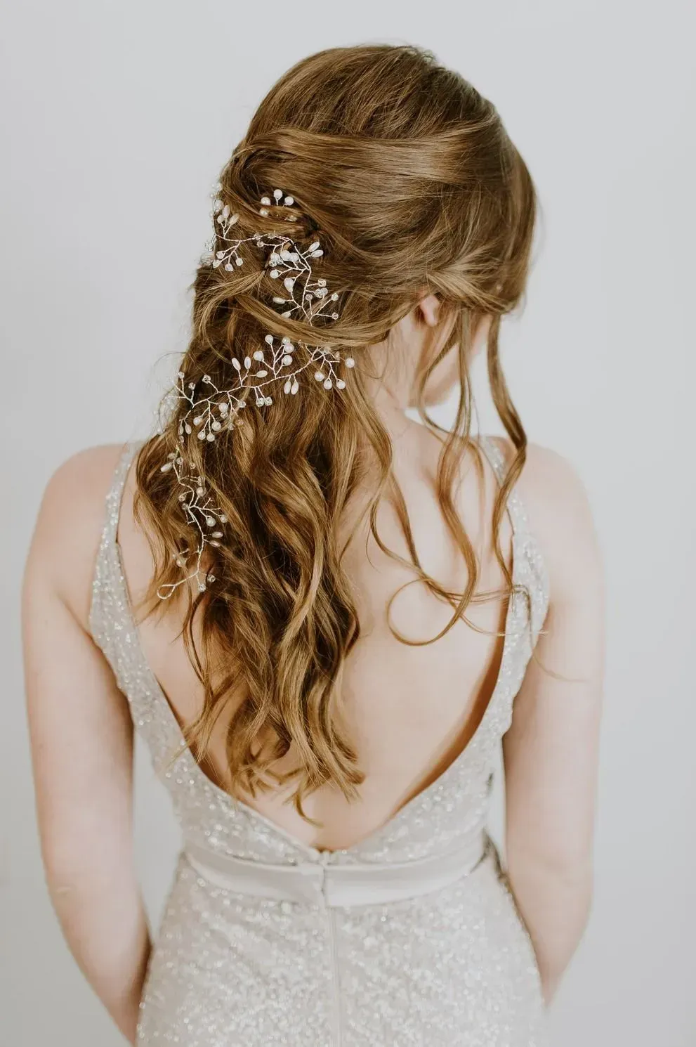 Woman with wavy brown hair, embellished with floral hairpins, wearing a sparkly gown. — Wow! Excellence in Hair in Toowoomba, QLD