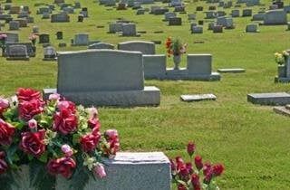 A cemetery filled with lots of graves and flowers.