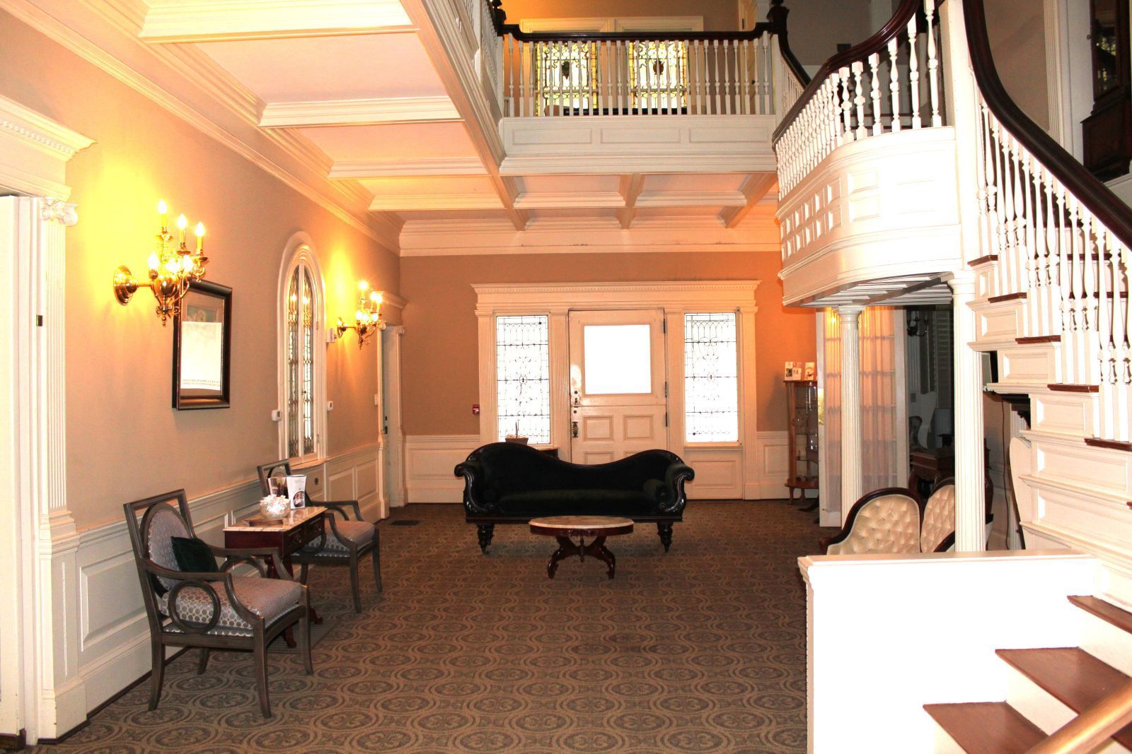 A living room with a couch and chairs and stairs