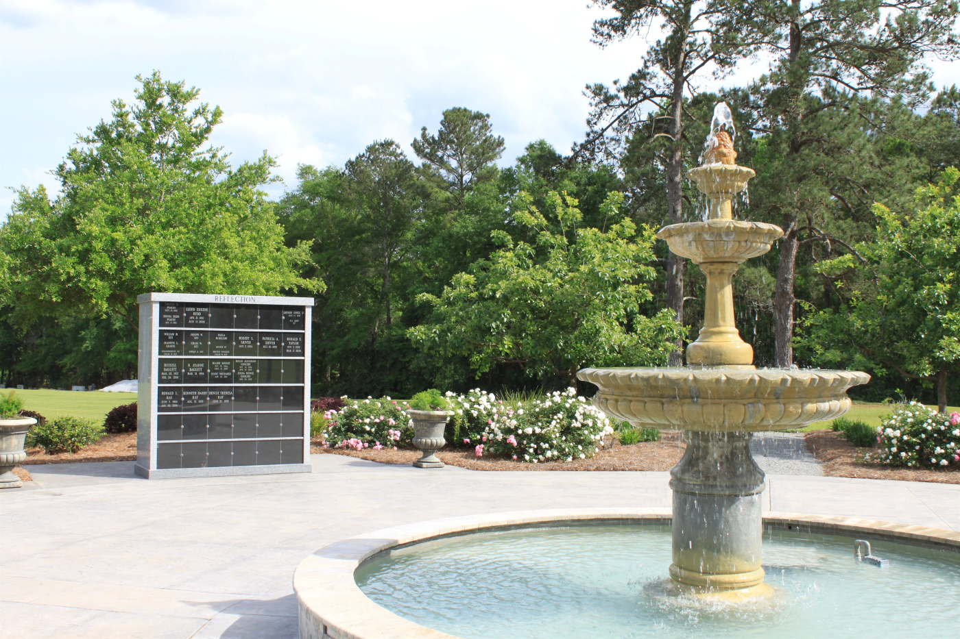 A fountain in a park with trees in the background