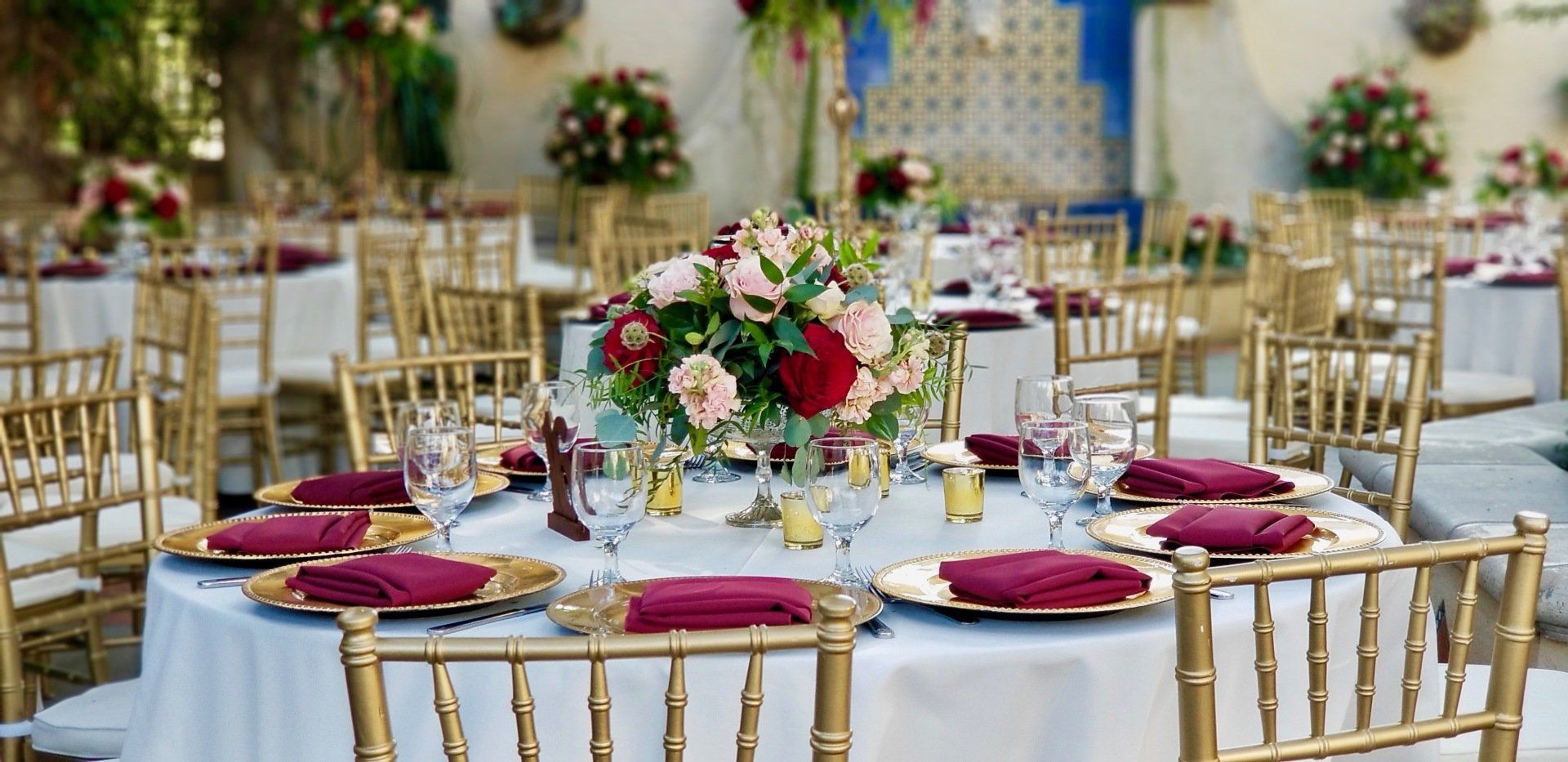 A table set for a wedding reception with a vase of flowers on it.