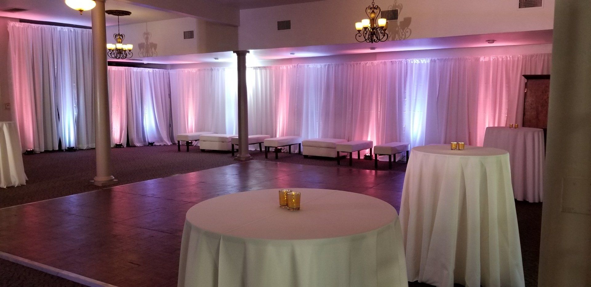 A large room with tables and candles in it