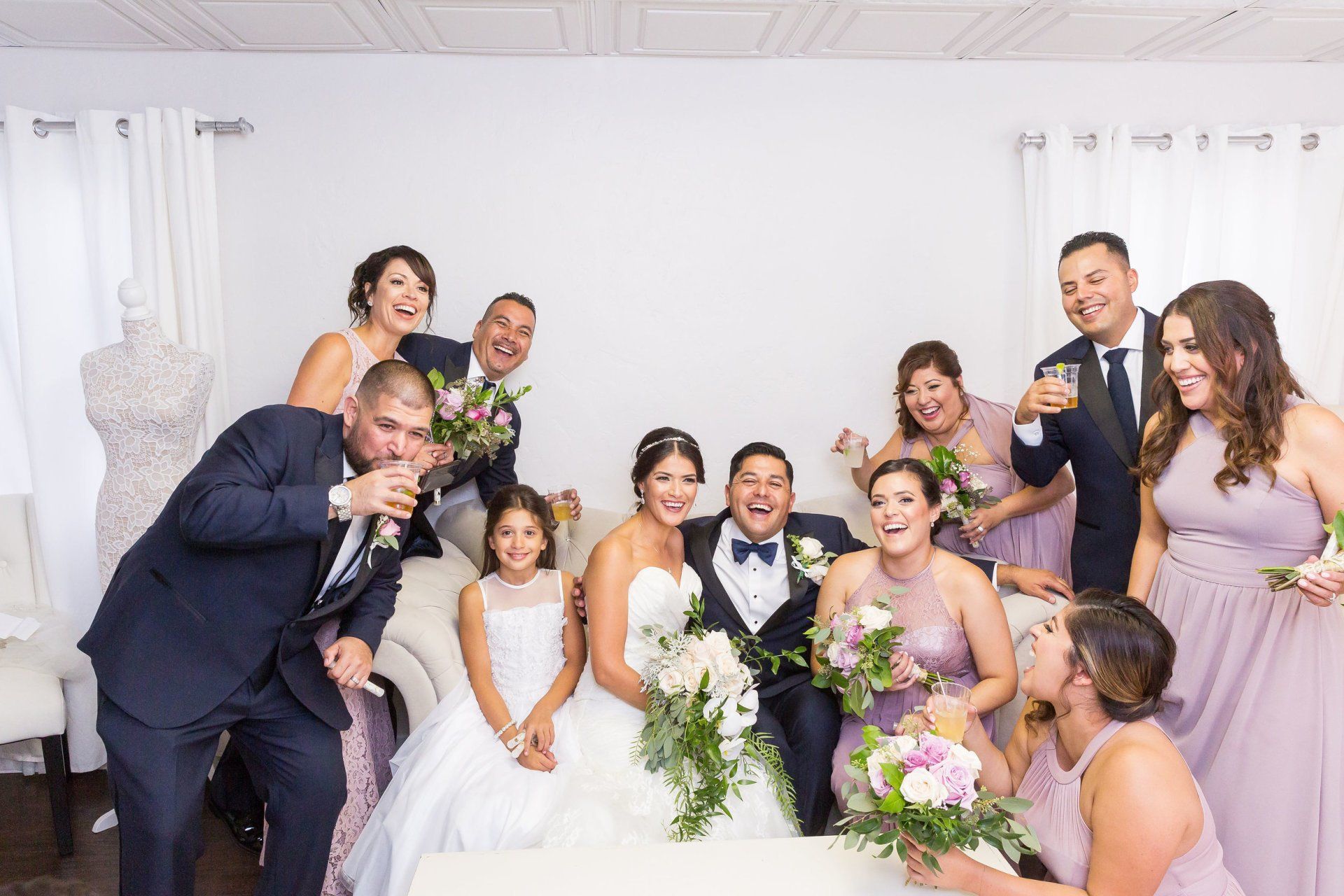 A bride and groom are posing for a picture with their wedding party.