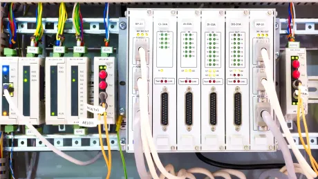 A close up of a electrical panel with a lot of wires coming out of it.