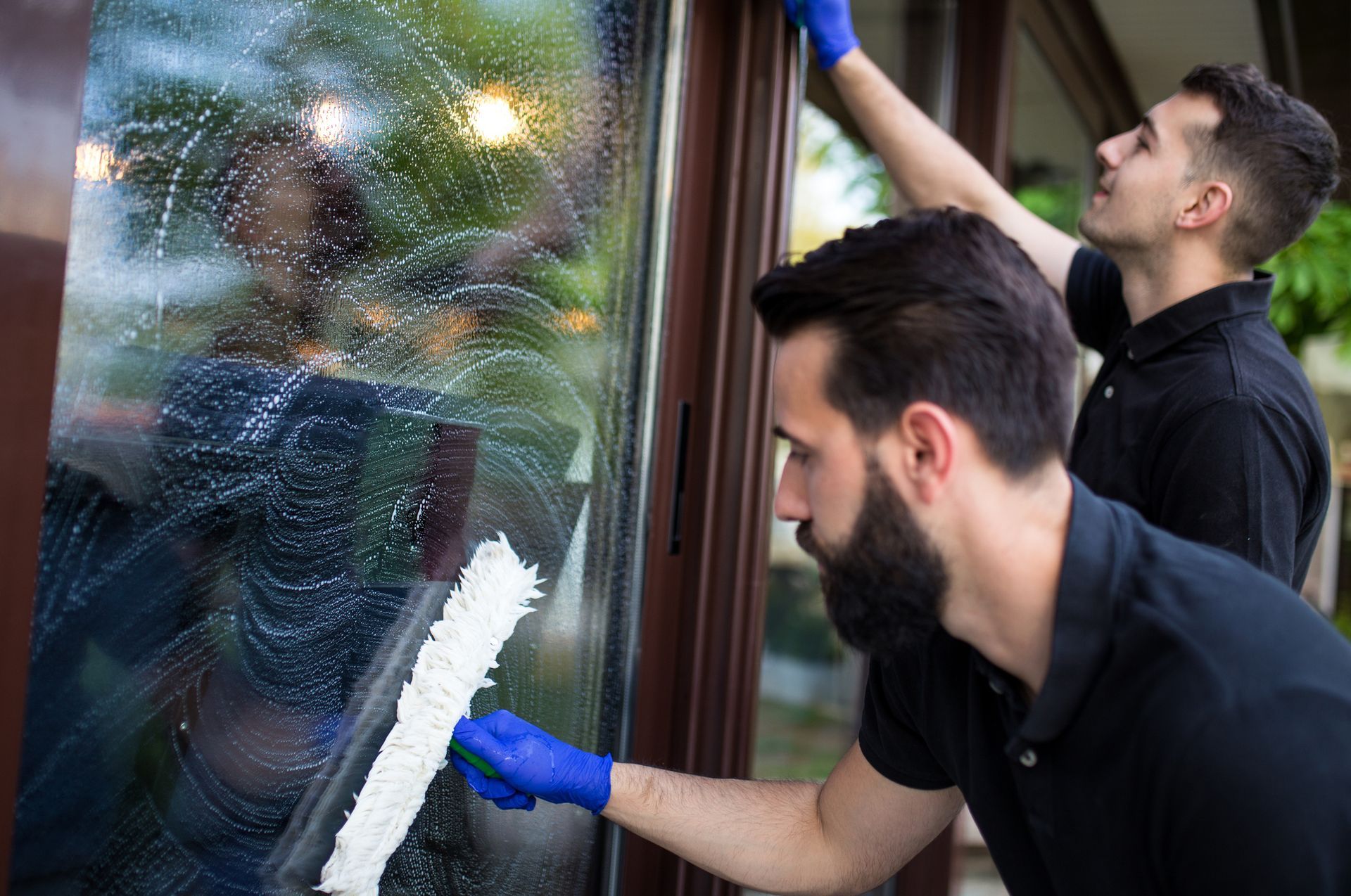 Workers Are Cleaning A Window — Coconut Creek, FL — American Window Washing & Pressure Inc.