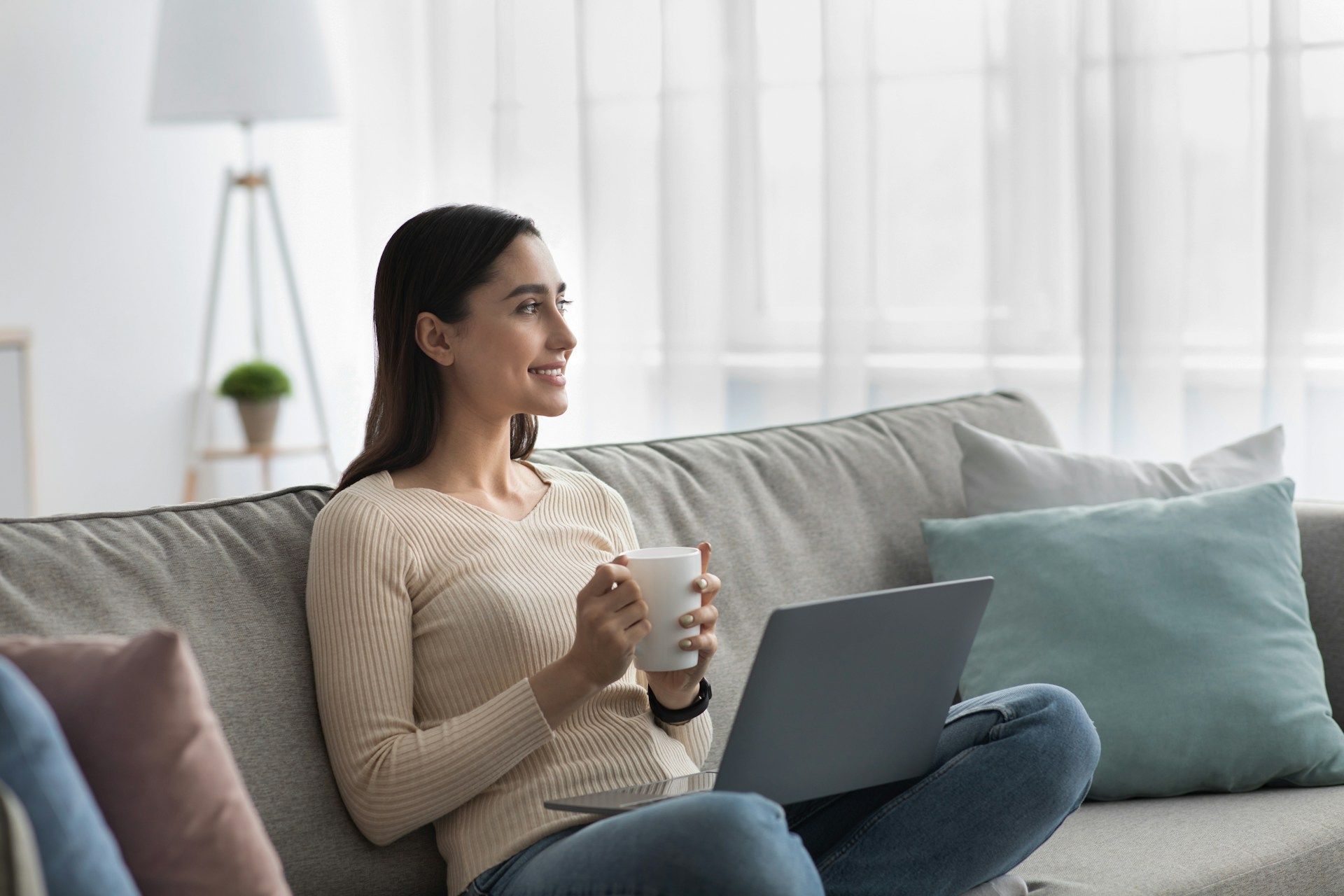 Woman in glasses on the phone, smiling, looking at papers, wearing a patterned blazer.
