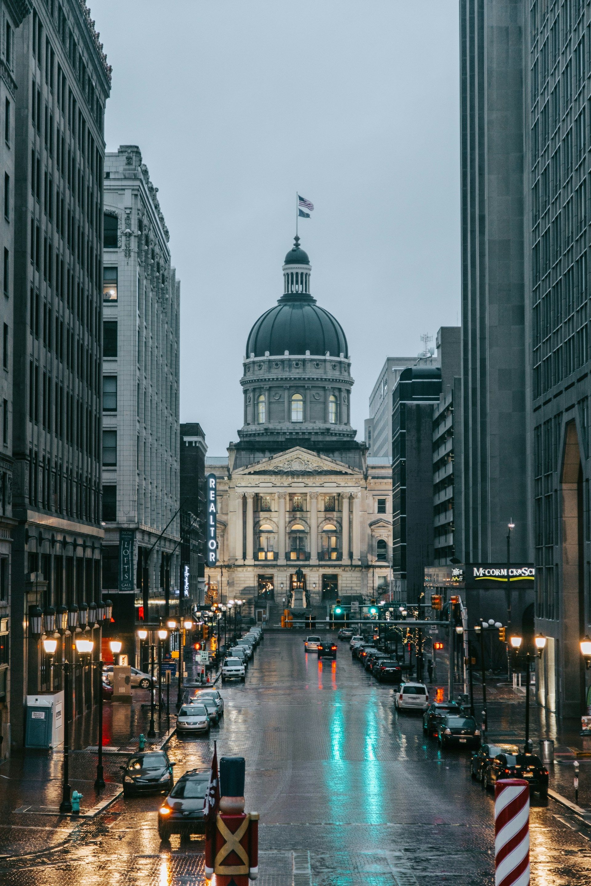 Person using calculator with paperwork, laptop, and coffee on a table.