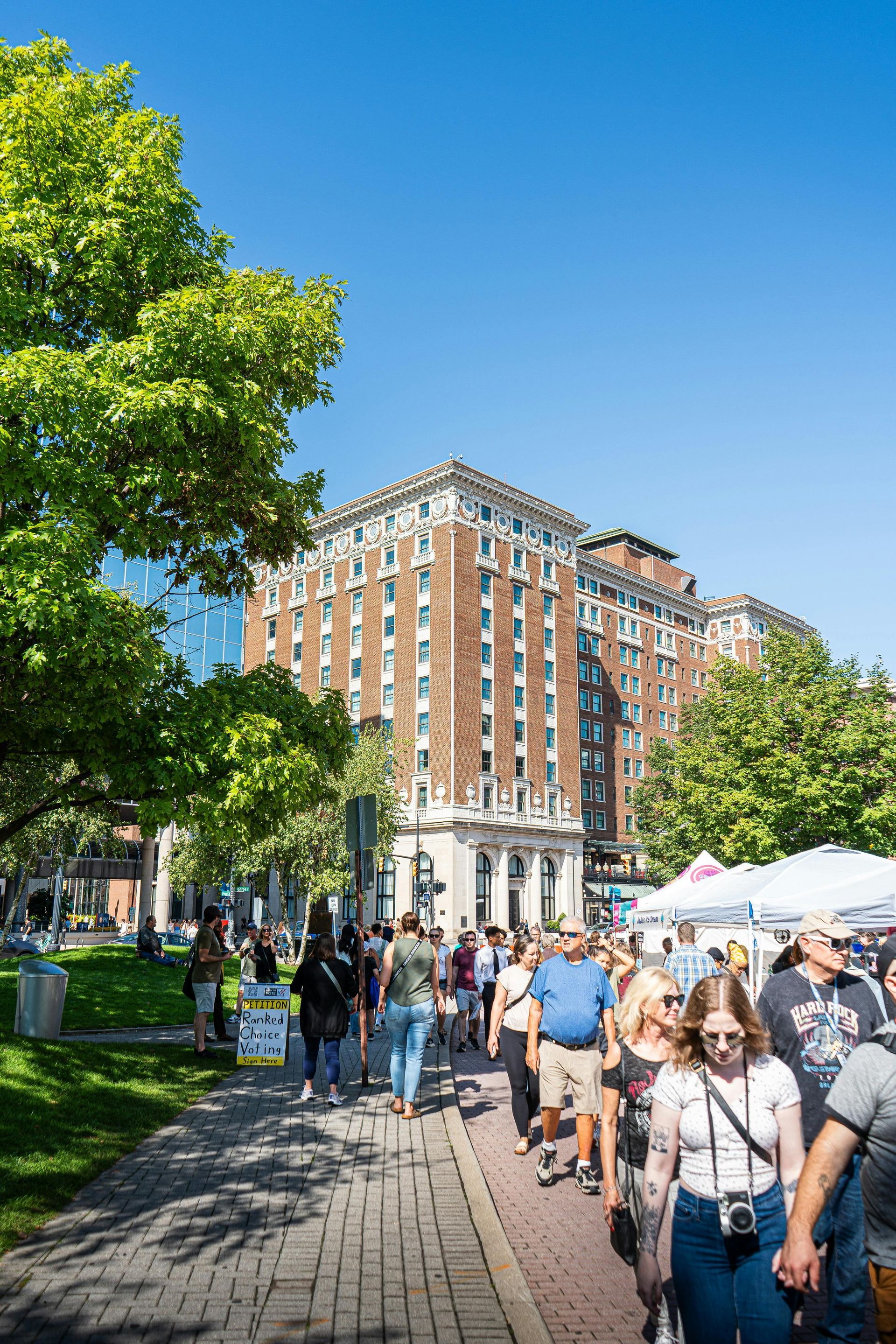 Person using calculator with paperwork, laptop, and coffee on a table.