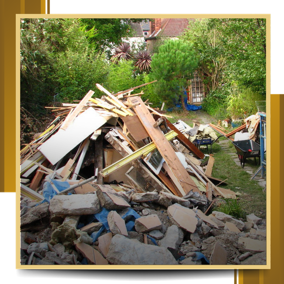 Pile of demolition debris in a backyard, including wood, concrete, and other materials.