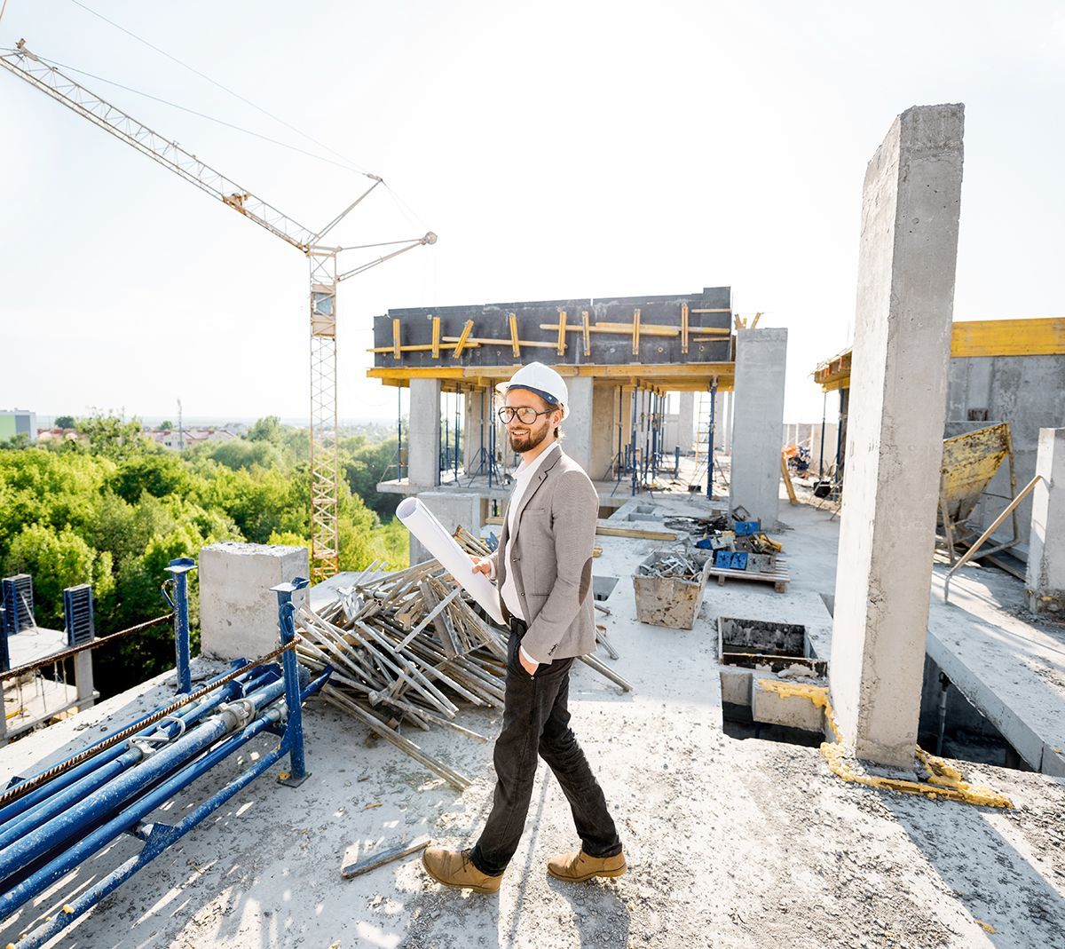 A man is walking on a rooftop of a building under construction. A man is walking on a rooftop of a building under construction.