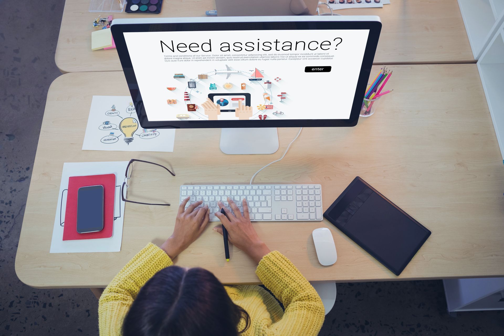 Person using computer on a wooden desk with
