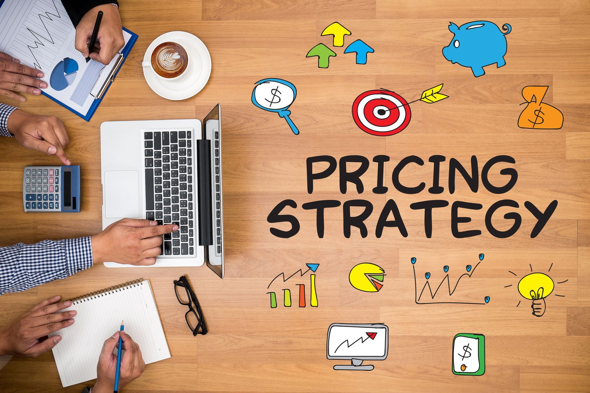 People at a table working on pricing strategy, with laptop, charts, and drawings.