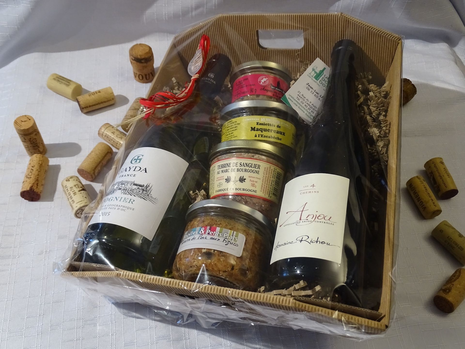 Un panier rempli de bouteilles de vin et de bocaux de nourriture