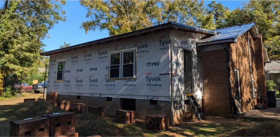 A small house is being remodeled in a backyard.