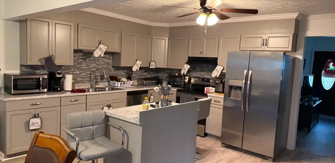 A kitchen with stainless steel appliances and a ceiling fan.