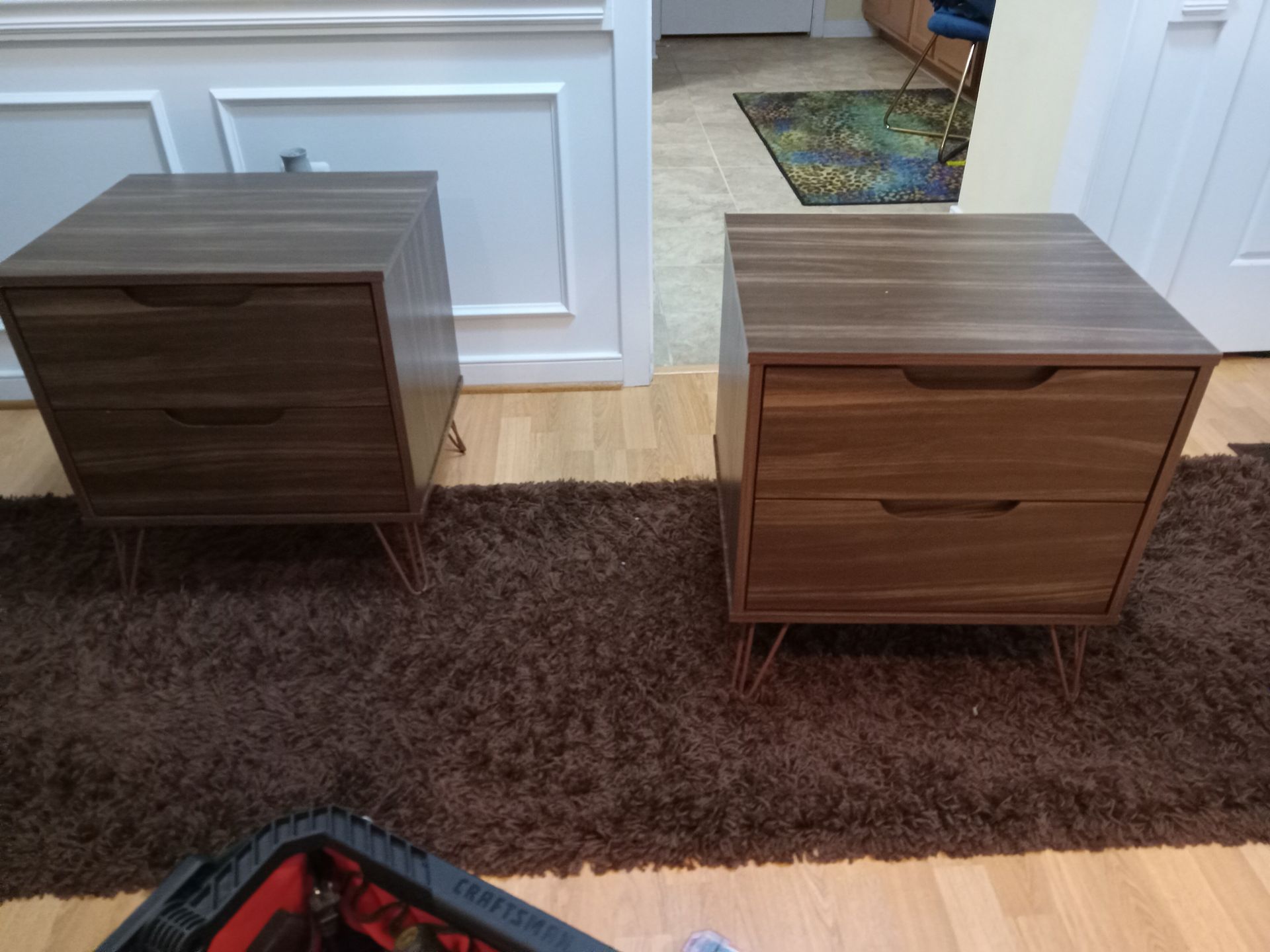 Two nightstands are sitting on a rug in a living room.