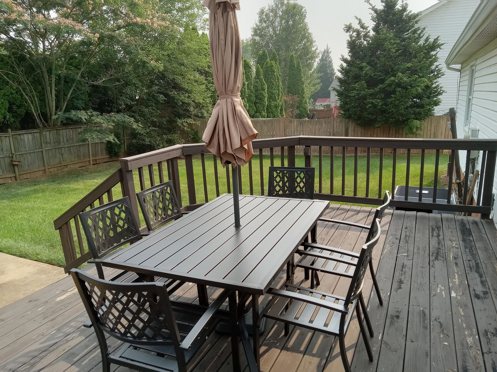 A wooden deck with a table and chairs and an umbrella