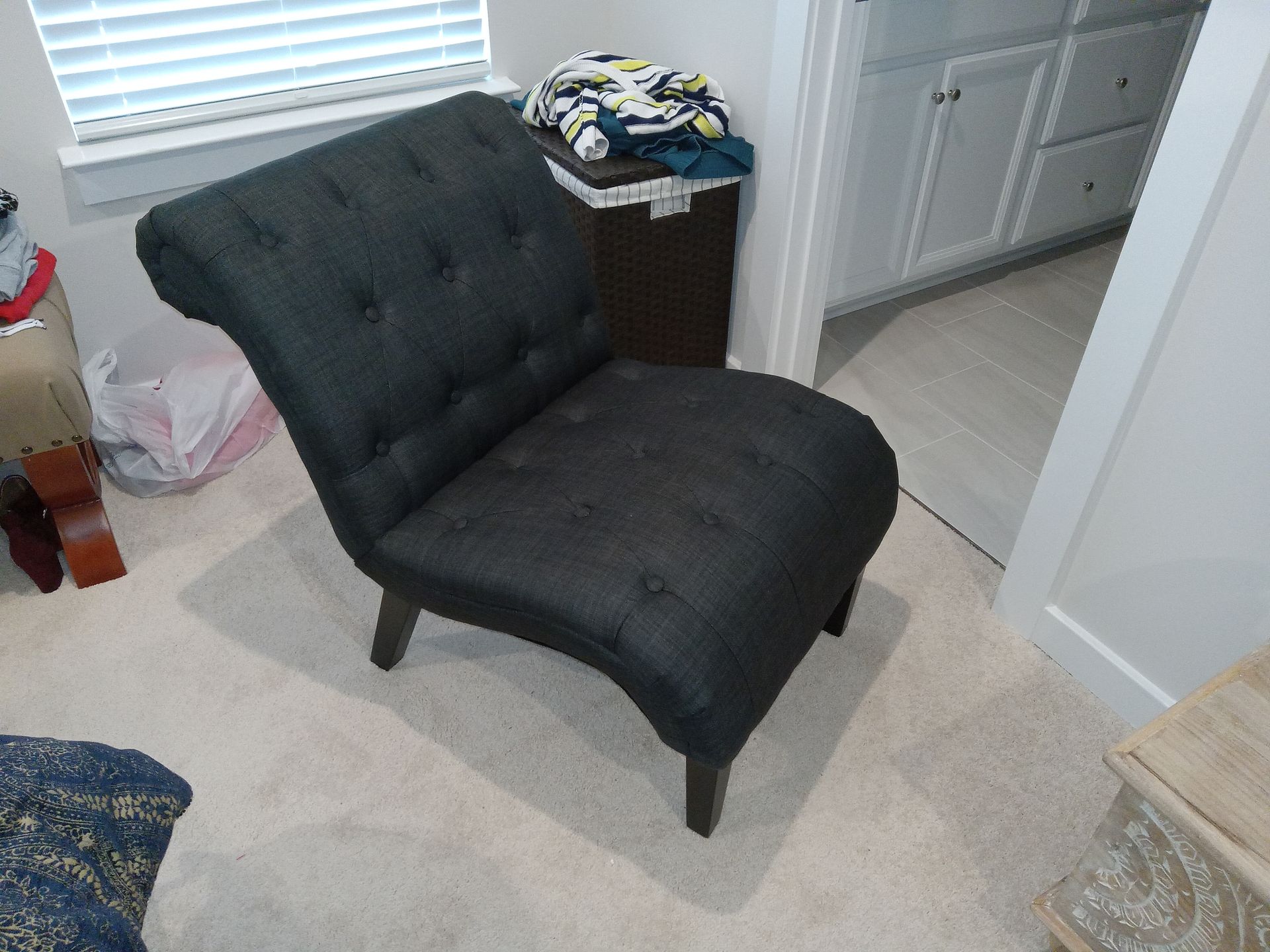 A black chair is sitting in a room next to a window