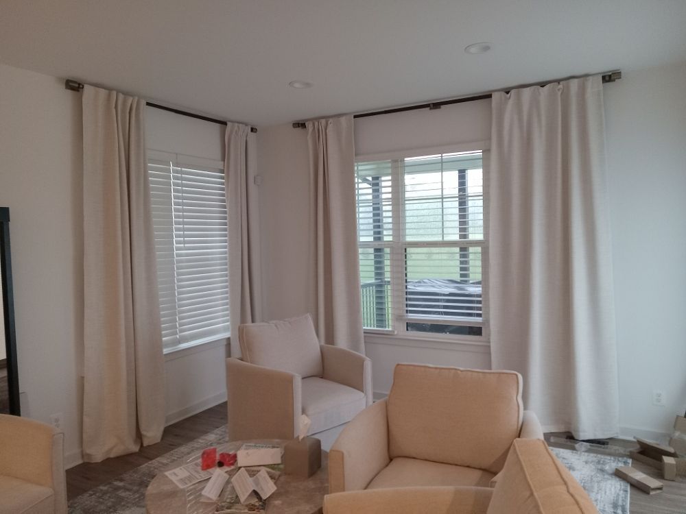 A living room with two chairs , a couch , a table and a window.