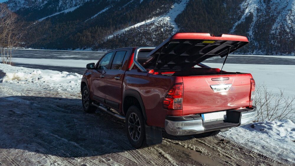 A Red Truck Is Parked on A Snowy Road with Its Trunk Open — Multidrive Parts Australia in Tamworth, NSW