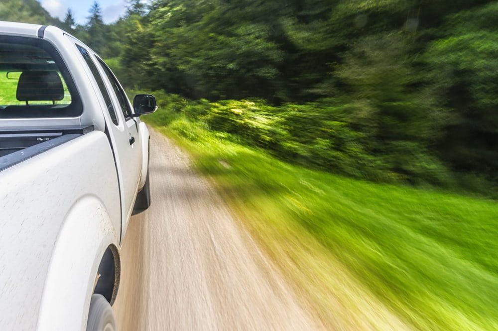 A White Truck Is Driving Down a Dirt Road — Multidrive Parts Australia in Gunnedah, NSW