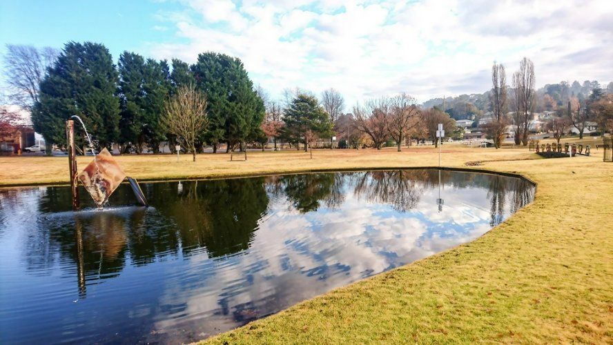 There Is a Pond in The Middle of A Park with Trees in The Background — Multidrive Parts Australia in Armidale, NSW