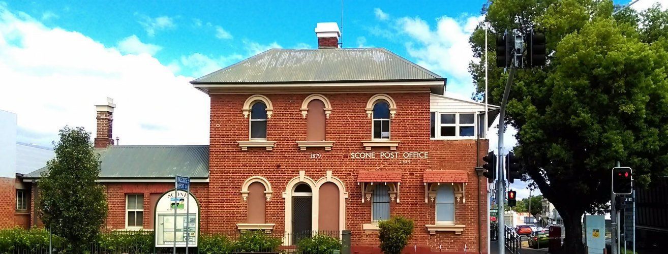A Large Brick Building with Arched Windows and A Roof — Multidrive Parts Australia in Scone, NSW