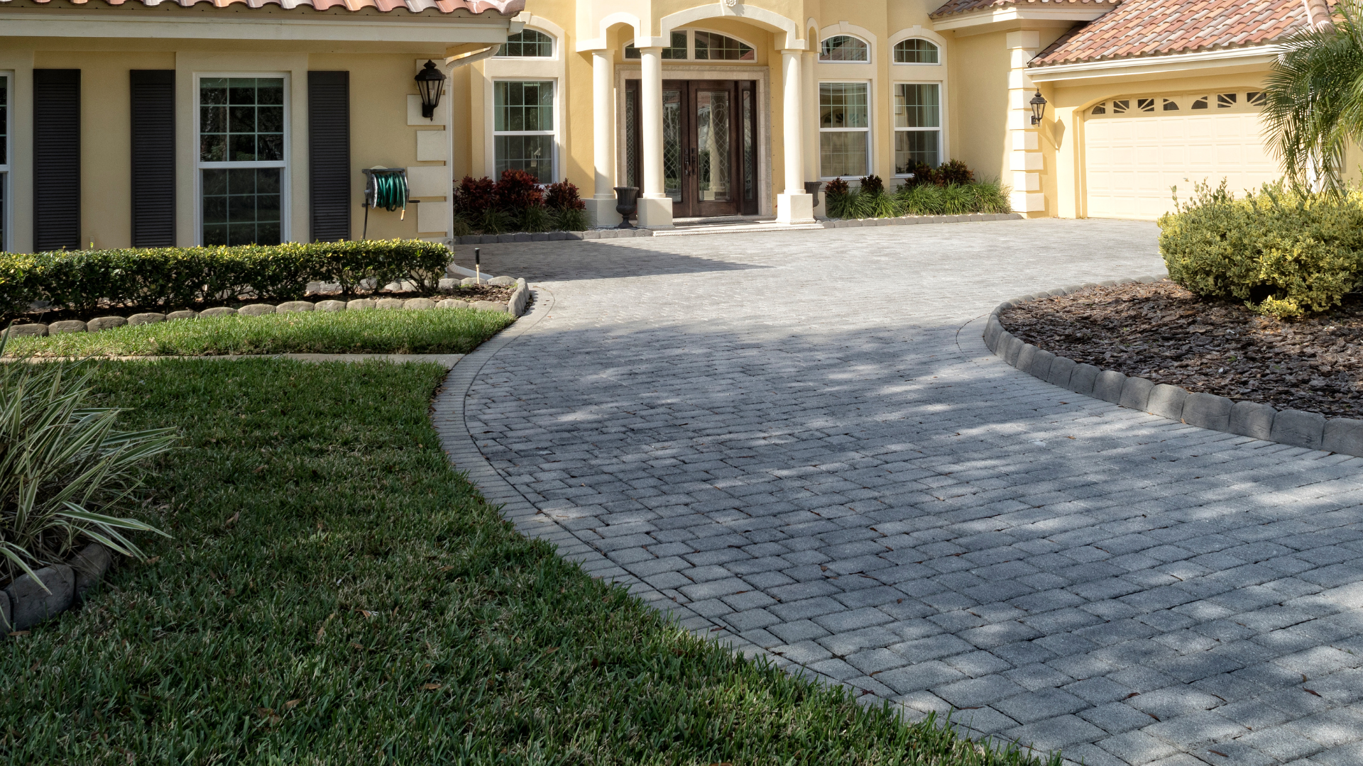 a large house with a brick driveway leading to it .