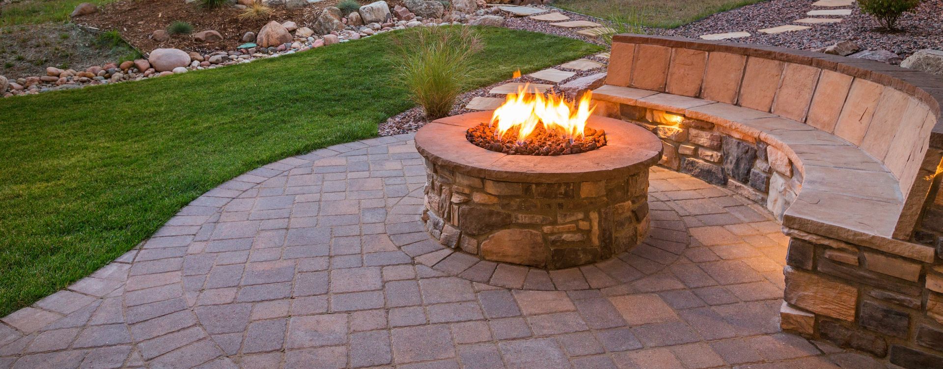 a fire pit is sitting on a patio next to a bench .