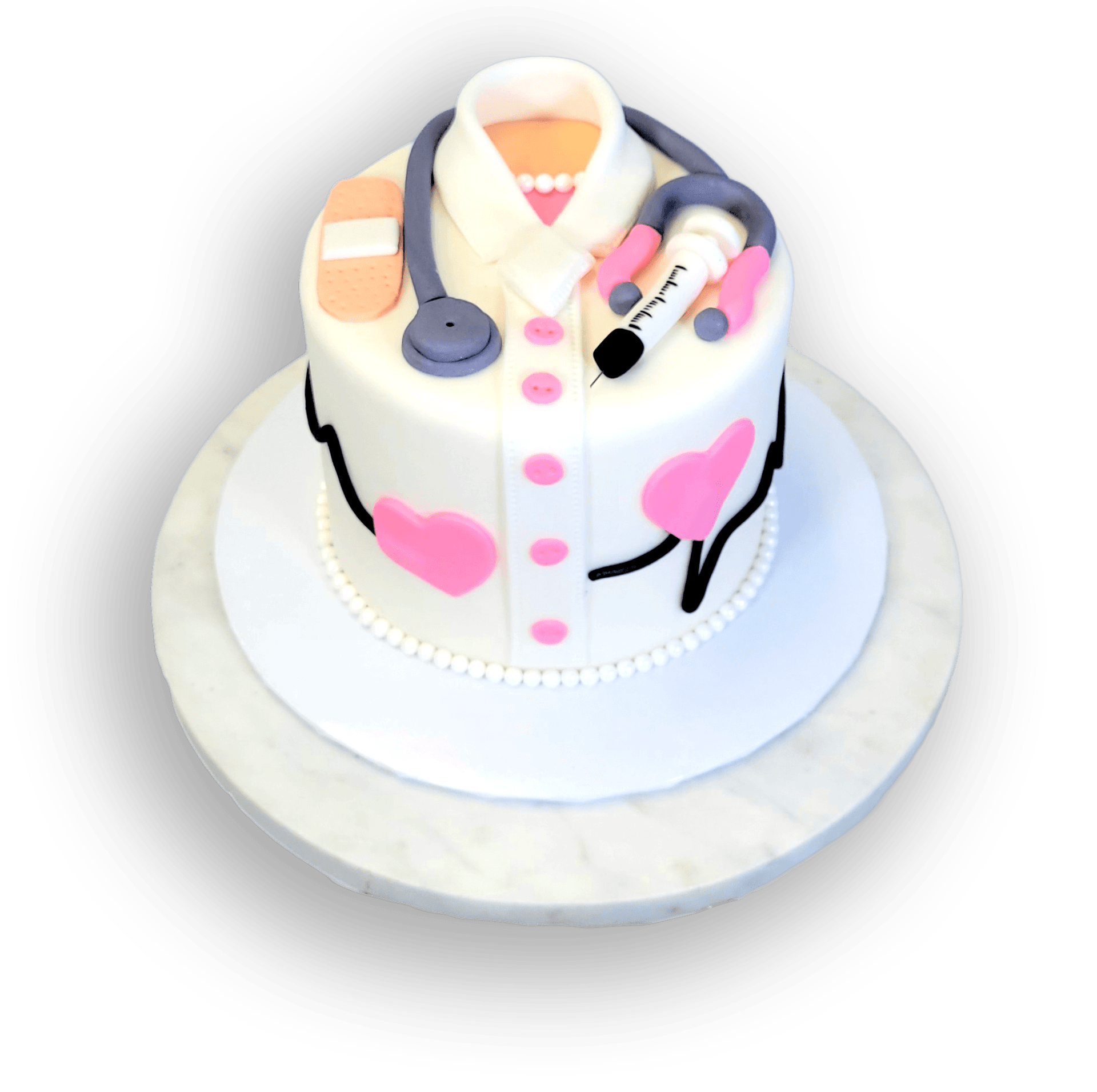 A white cake decorated as a medical uniform with a stethoscope, syringe, bandage, hearts, and a heartbeat line.