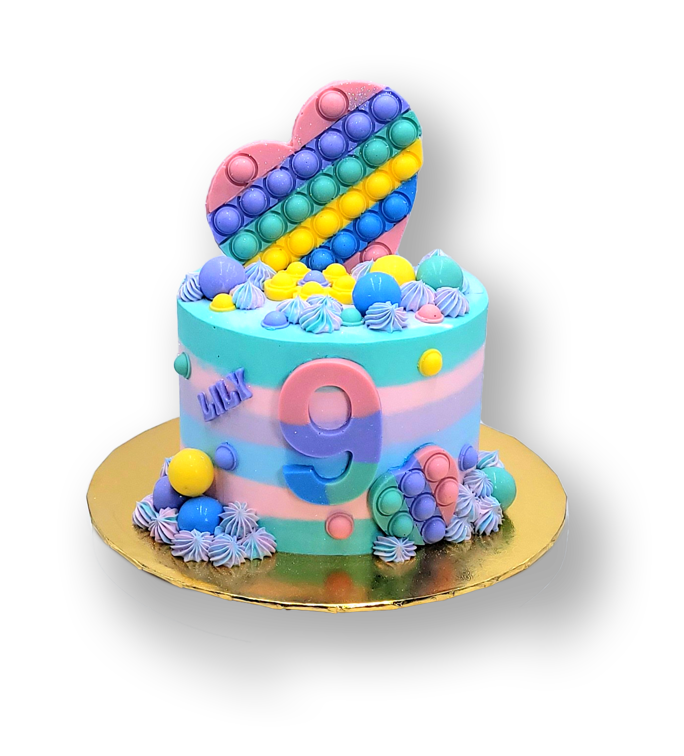 A round birthday cake decorated in pastel stripes with a heart-shaped rainbow pop-it topper and a large number nine.