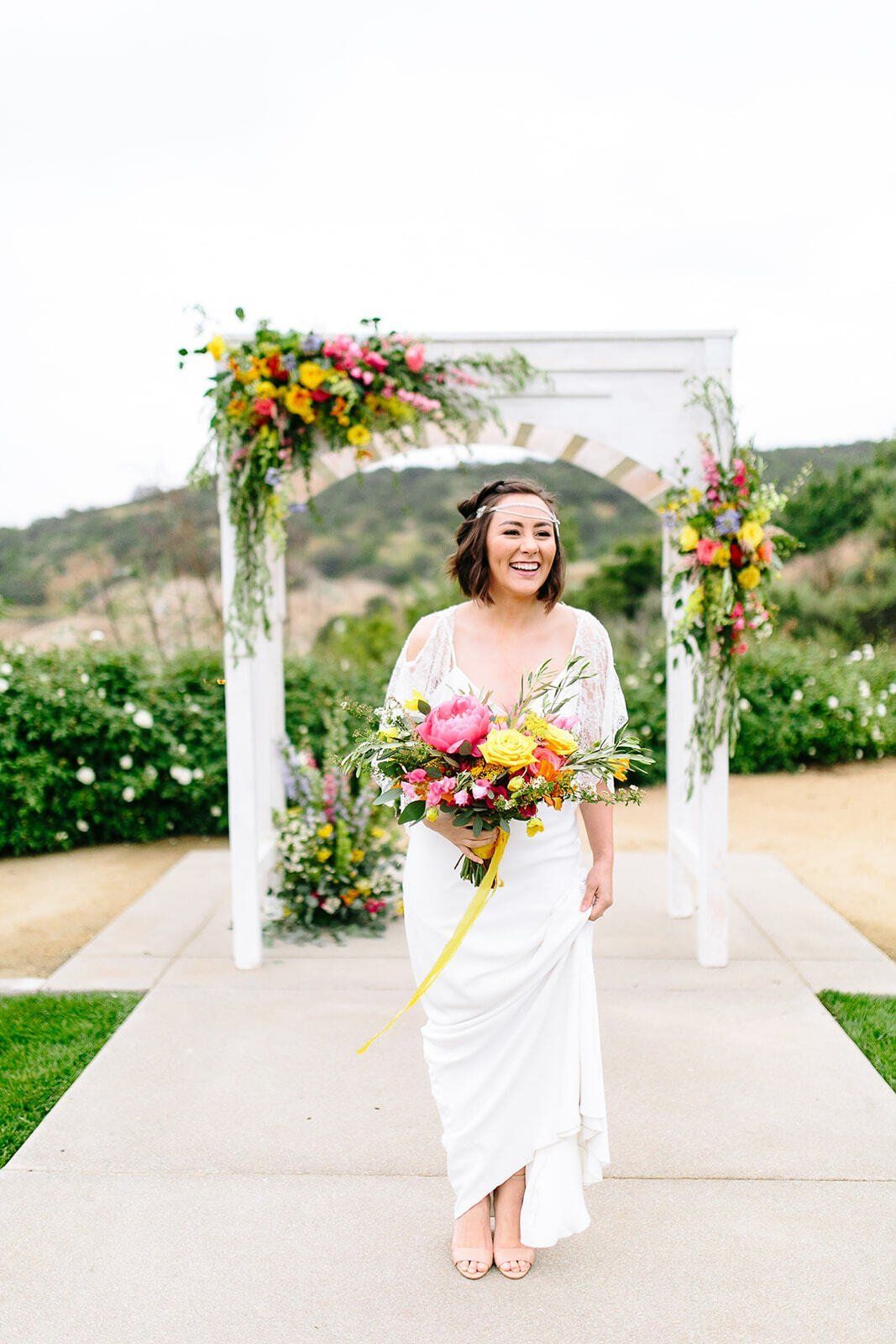 The bride is wearing a white dress and holding a bouquet of flowers.