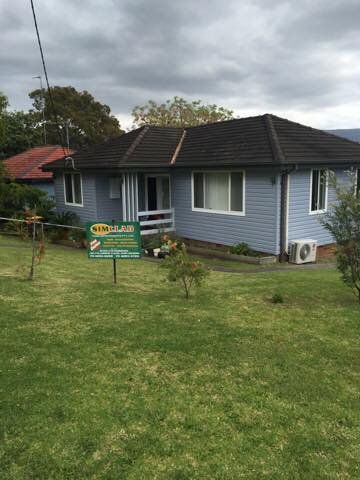 House with Green Signage — Simclad Home Improvements in Wollongong