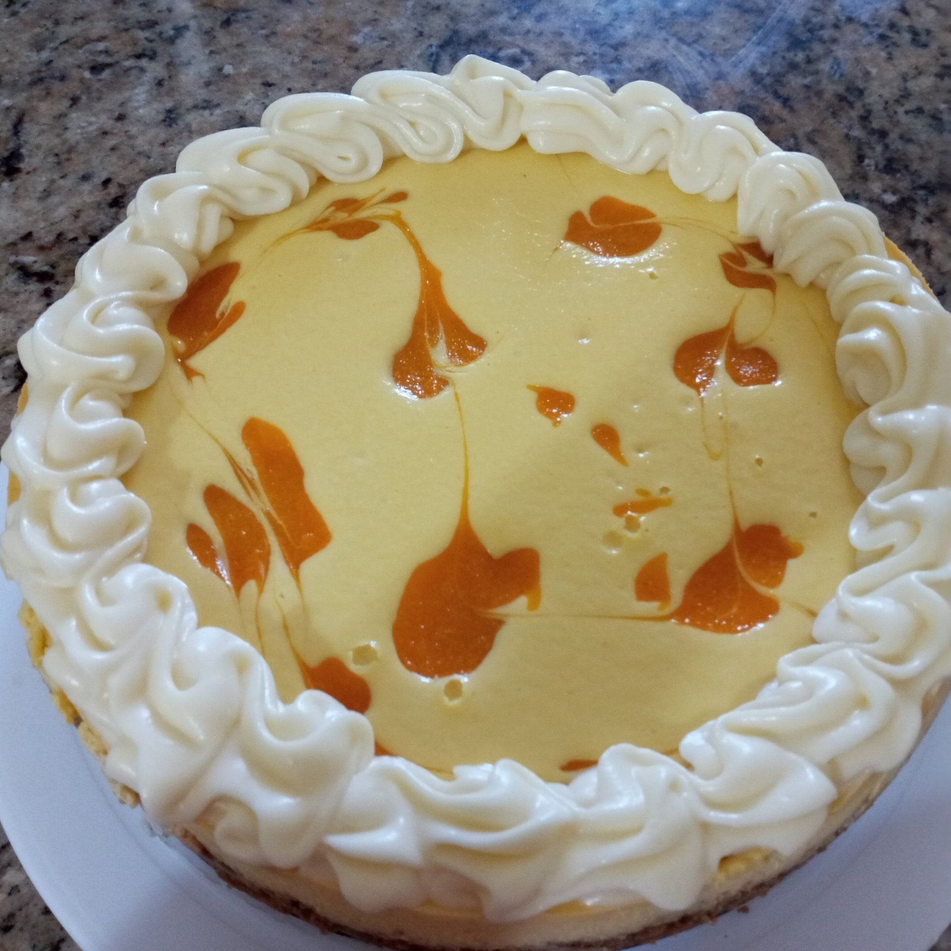 A cheesecake with whipped cream and caramel on top