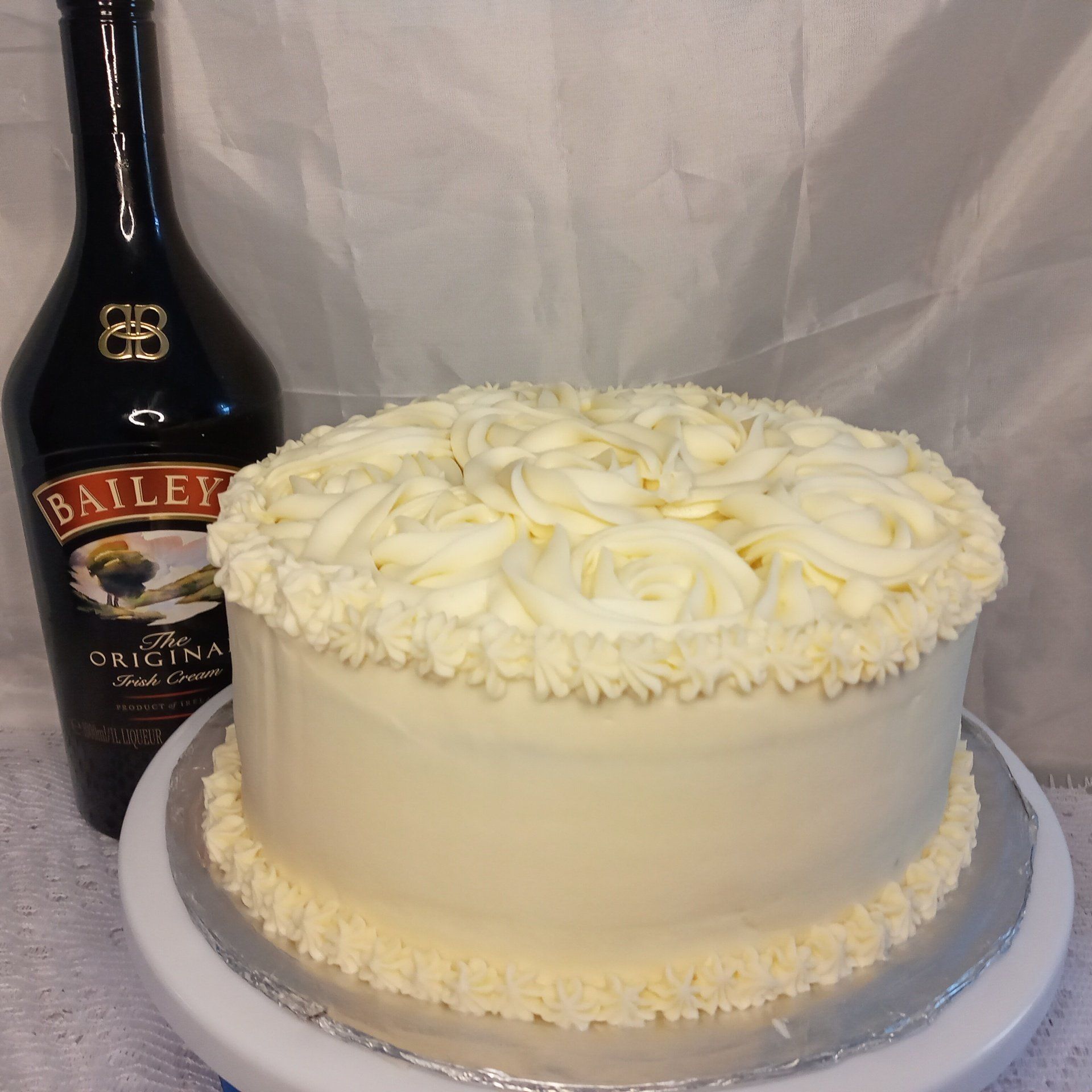 A bottle of baileys sits next to a cake