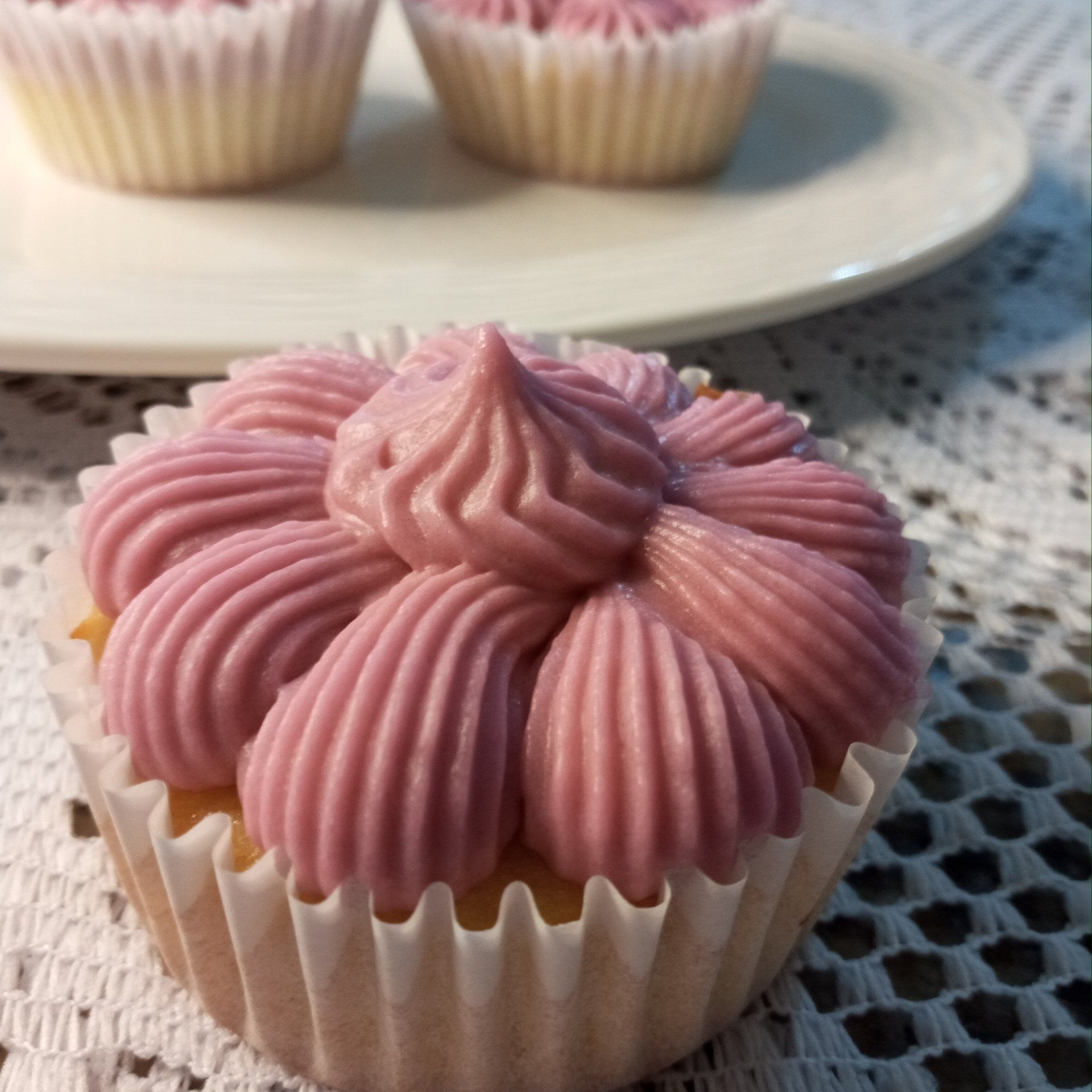 A close up of a cupcake with pink frosting