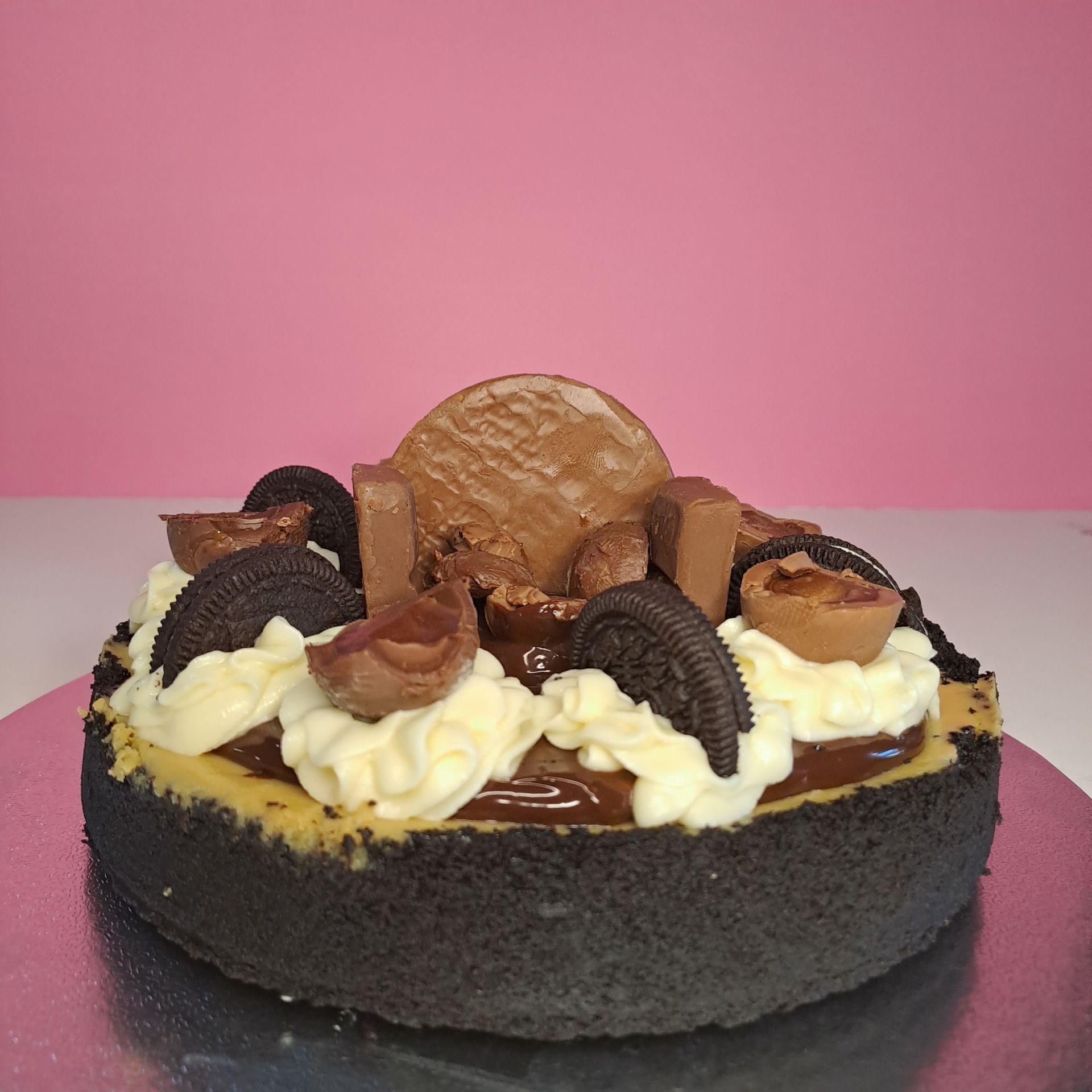 A cheesecake with chocolate and oreos on top of it